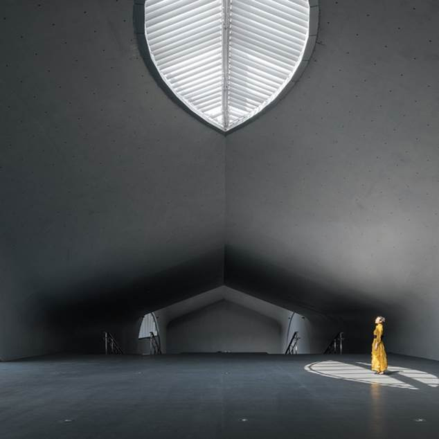 Interior de un espacio de arte subterráneo moderno con arquitectura minimalista e iluminación dramática.