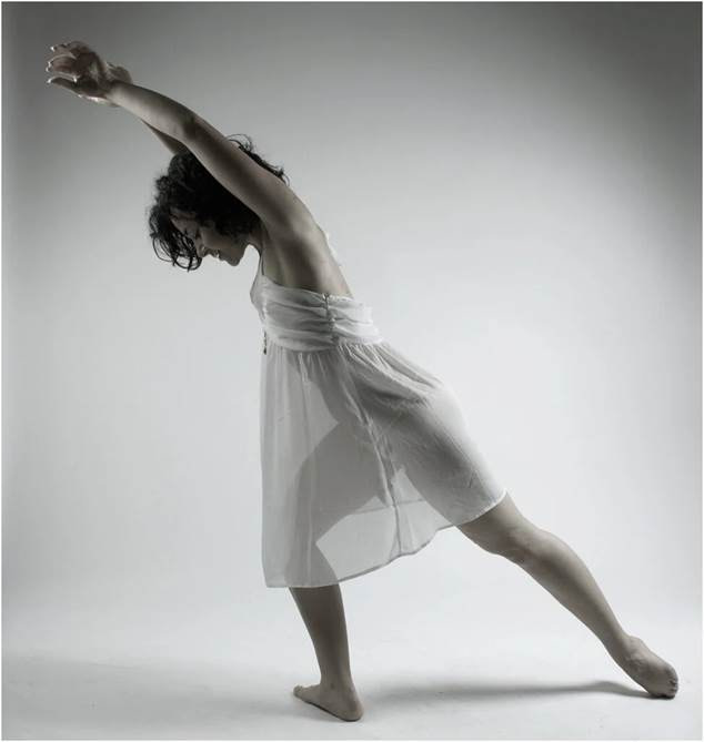 Persona realizando una pose de danza libre expresiva, resaltando el movimiento creativo como técnica para superar bloqueos creativos.