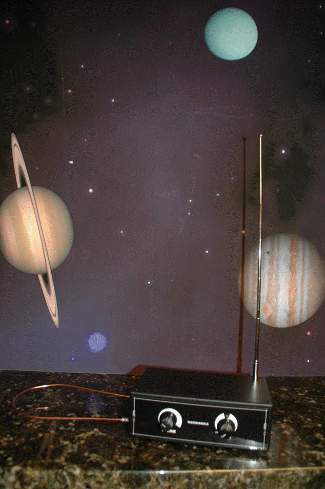 Instrumento musical Theremin con antenas de volumen y tono sobre un fondo de temática espacial.